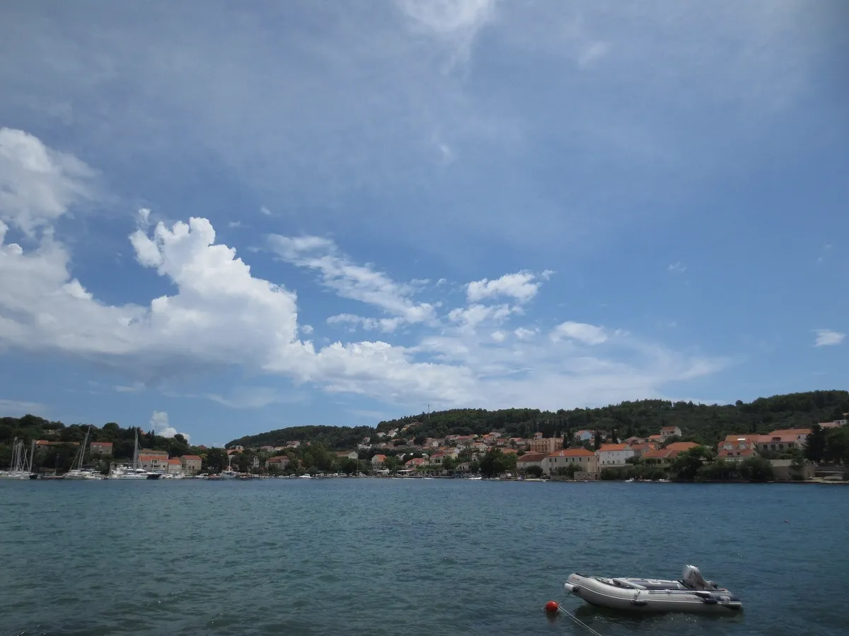 Boats along the Lumbarda waterfront on Korcula in Croatia with the village beach behind
