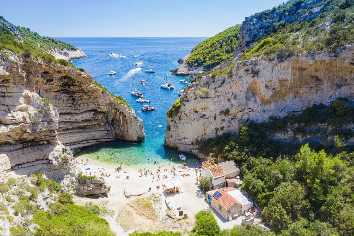 Turquoise cove between white limestone cliffs seen from above on the Dalmatian coast near Korcula