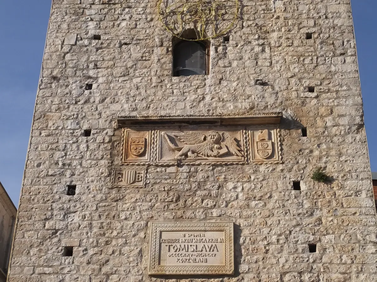 Stone gate tower of Korcula Old Town with a carved relief, the walls the riviera cruise shows from the water