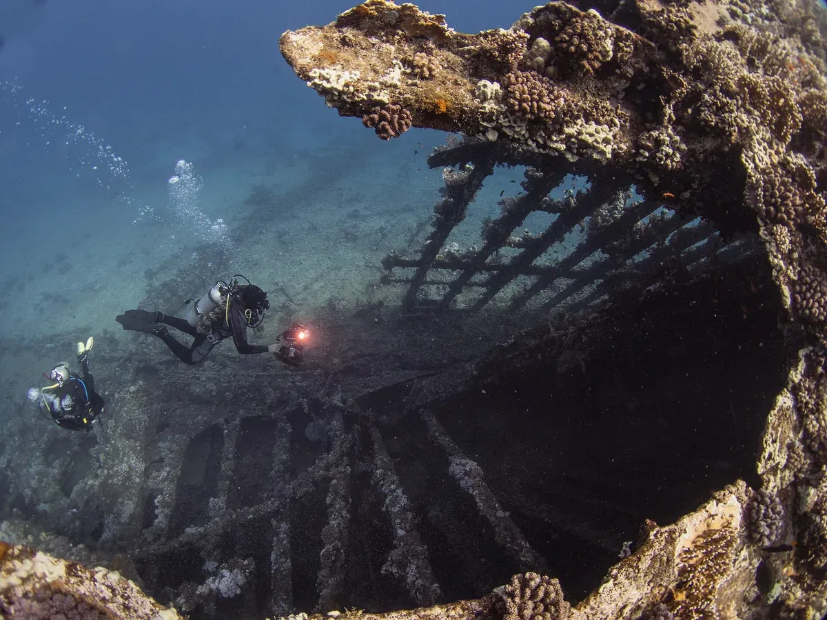 Divers exploring the ribs of a sunken cargo ship underwater, similar to the reefed Boka wreck off Mokalo near Korcula