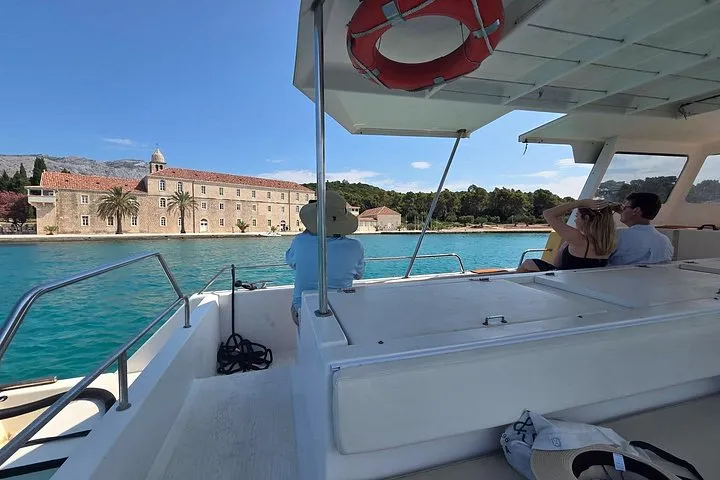 White sightseeing boat cruising past the walled old town of Korcula on the riviera sightseeing cruise in Croatia
